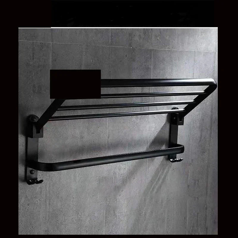 Black wall-mounted towel rack with hooks, modern bathroom accessory on concrete tile wall
