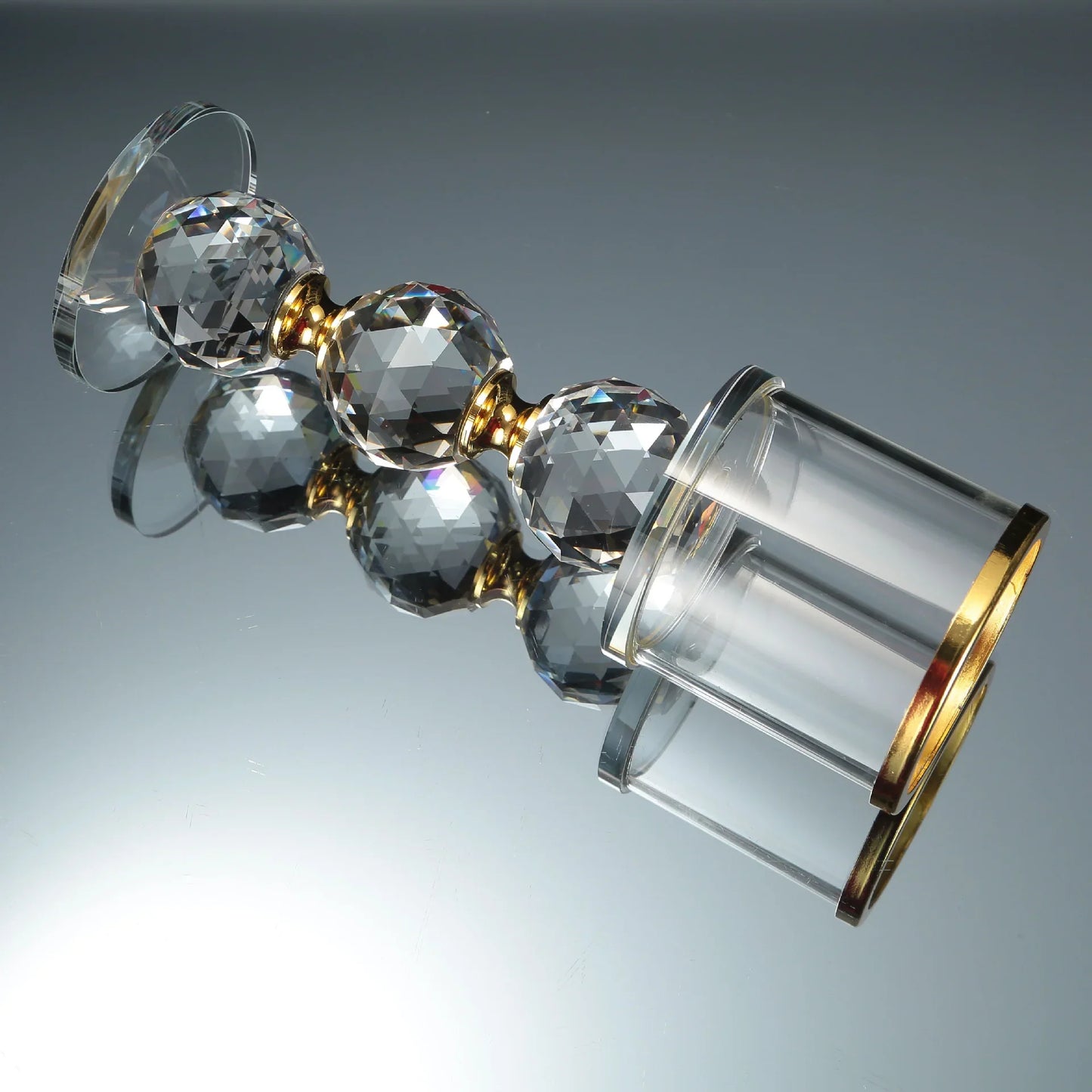 Elegant crystal candle holder with faceted spheres and gold accents, perfect for luxury home decor
