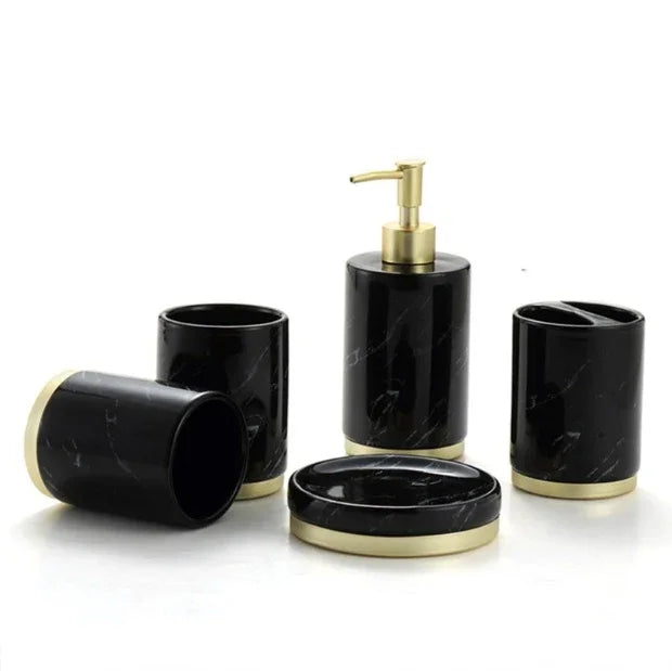 Black marble bathroom set with gold accents: soap dispenser, tumblers, soap dish