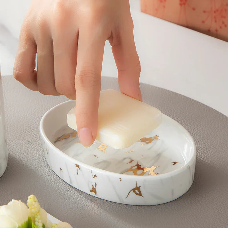 Elegant white marble soap dish with gold accents holding bar soap, ideal for bathroom or kitchen decor