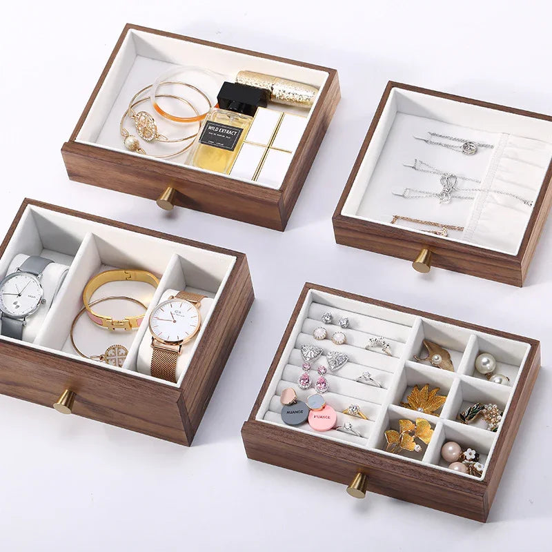 Wooden jewelry organizer drawers displaying watches, rings, earrings, and necklaces