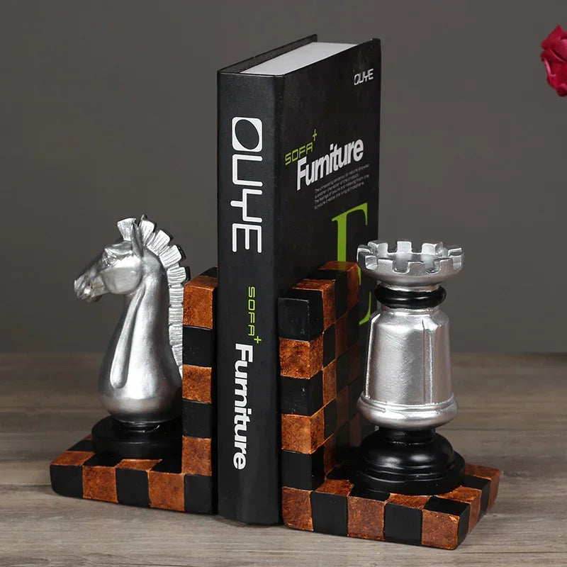 Silver chess knight and rook bookends on checkered base holding SOFA+ Furniture book