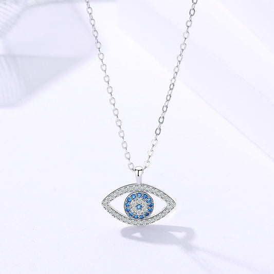 Silver chain necklace with blue evil eye pendant on white background, Greek jewelry