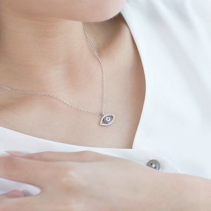 Silver evil eye pendant necklace on woman's neck, minimalist jewelry, close-up view