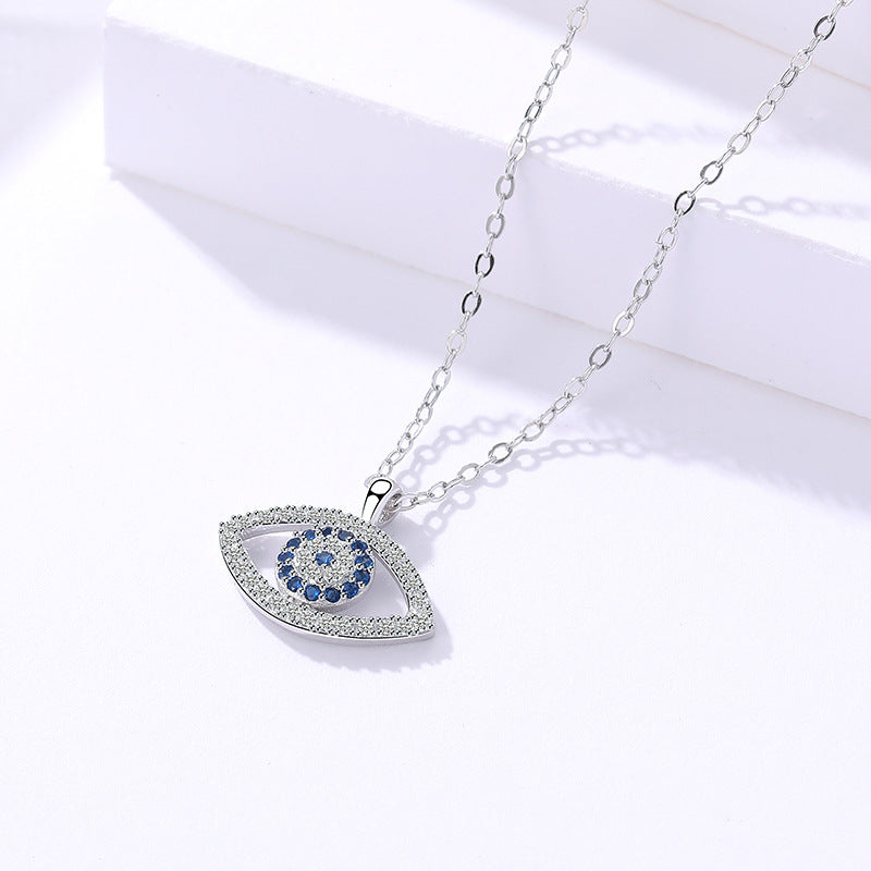 Silver evil eye pendant necklace with blue and white stones on a white background