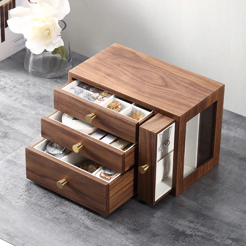 Wooden jewelry box with three open drawers and side necklace organizer on grey surface