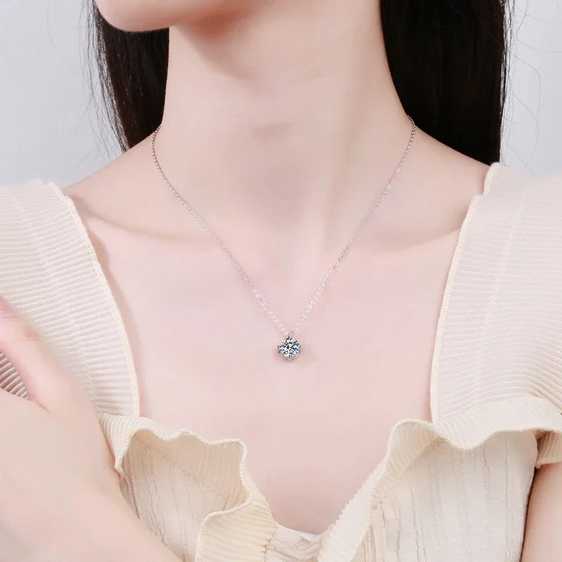 Silver pendant necklace with blue gemstone, worn with a cream ruffled top