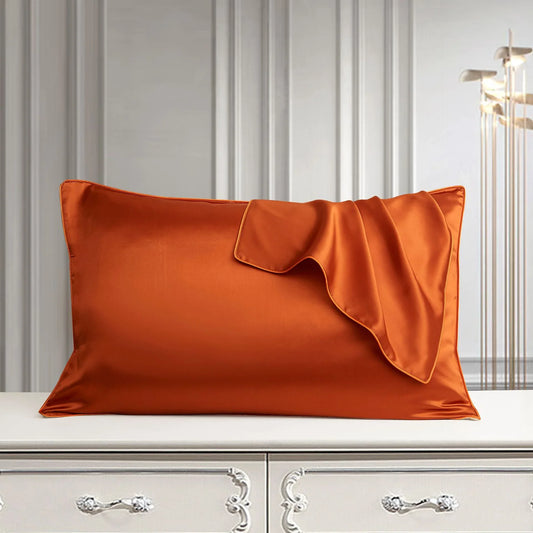 Luxury orange silk pillowcase on white dresser, elegant bedroom decor with satin finish and soft drape