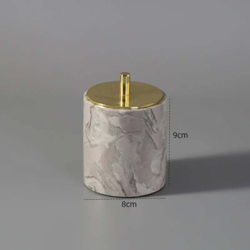 Round marble jar with gold lid, 9cm tall, 8cm wide, on a gray background