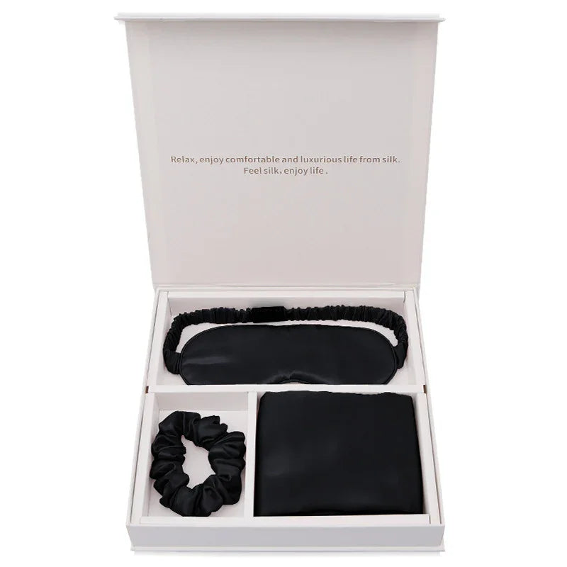 Luxury black silk sleep mask, scrunchie, and pillowcase gift set in open box