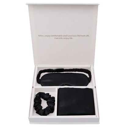 Luxury black silk sleep mask, scrunchie, and pillowcase gift set in open box