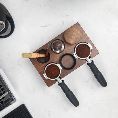 Espresso preparation set with portafilters, tamping station, tamper, and coffee grounds on a marble countertop