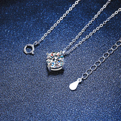 Silver chain necklace with round solitaire crystal pendant on textured blue background