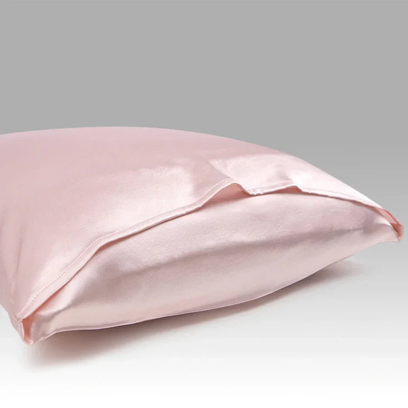 Light pink satin pillowcase on a pillow against a neutral background