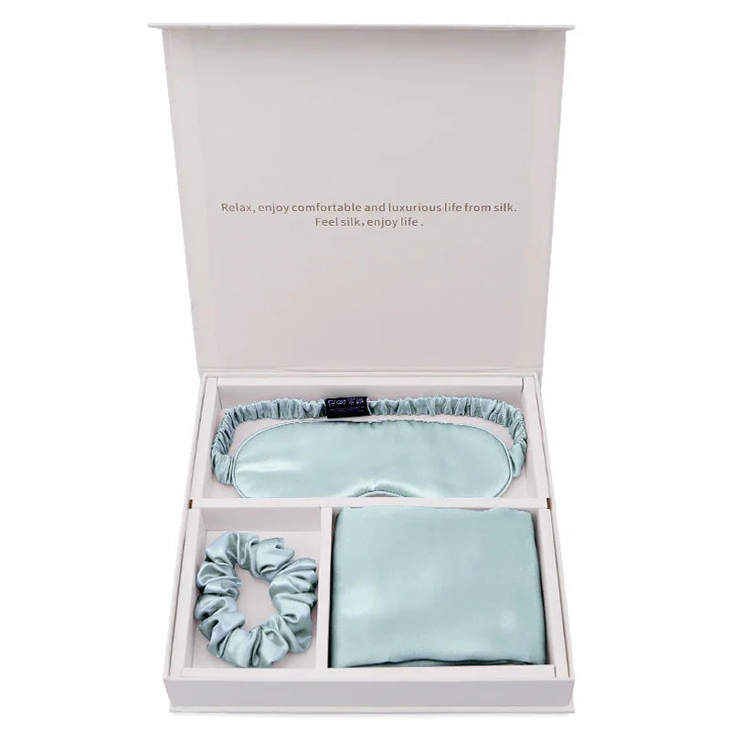 Silk sleep set gift box with eye mask, scrunchie, and pillowcase in light blue.