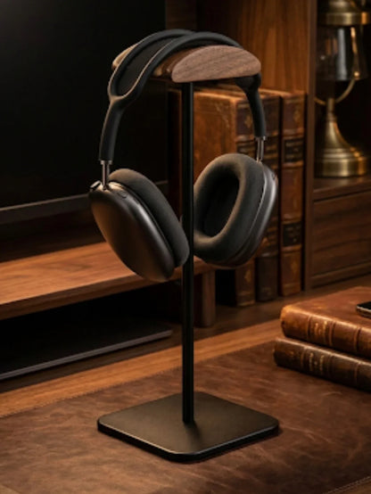 Over-ear wireless headphones on wooden stand in elegant office with leather books
