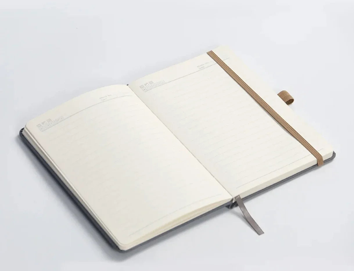 Open lined notebook with elastic band and pen holder on white background