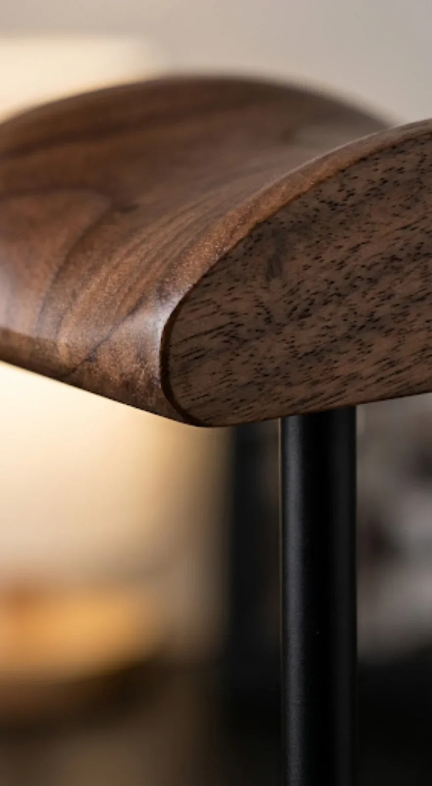 Close-up of a wooden furniture edge with a black metal leg, modern interior detail