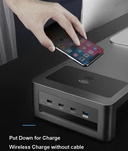 Hand placing smartphone on wireless charger with multiple USB ports on a modern desk